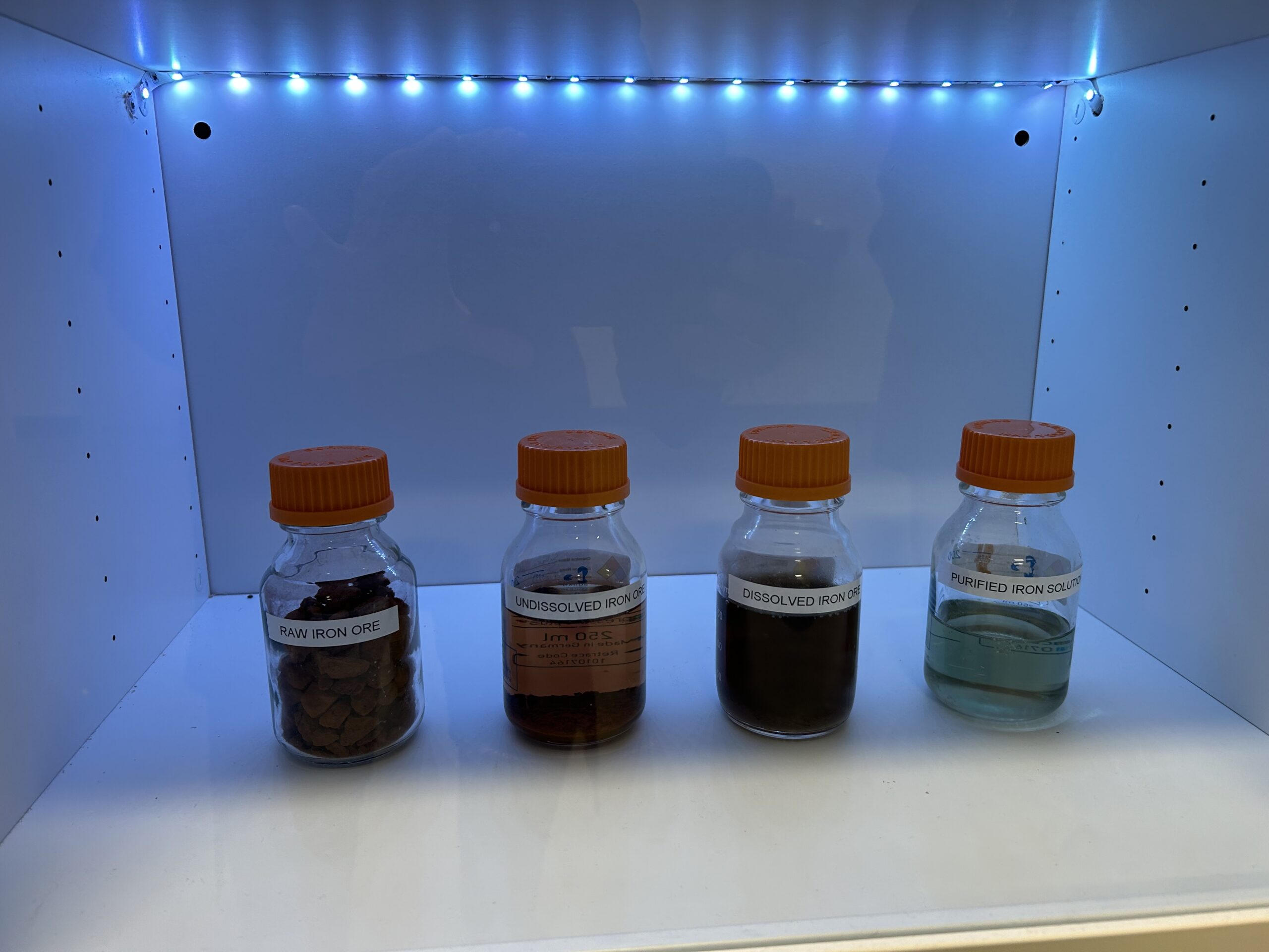 Four bottles the stages of converting raw iron ore to pure iron in solution. 