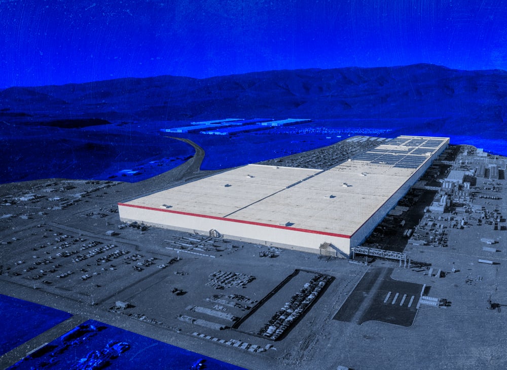 Illustration of a large, white factory building in a desert surrounded by mountains.