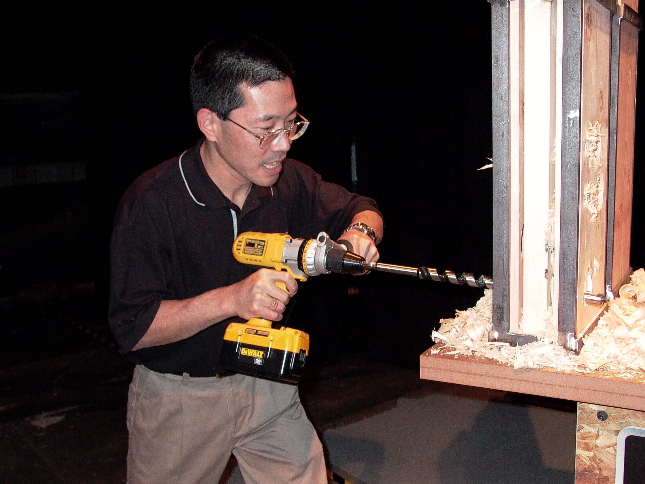 A man uses a power drill.